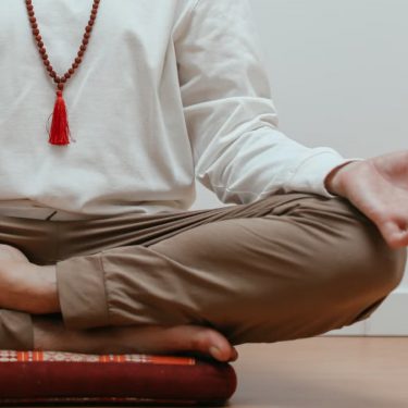 Close-up of a person meditating in a serene indoor setting, focusing on mindfulness.