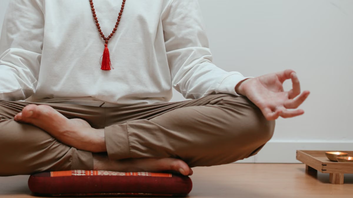 Close-up of a person meditating in a serene indoor setting, focusing on mindfulness.